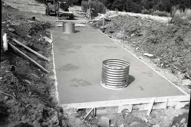 Septic tank with its concrete lid poured and access riser in place (historic photo)
